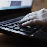Hand typing on a laptop keyboard